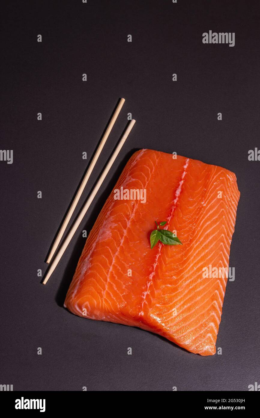 Fresh raw salmon or trout sea fish fillet on black stone background ...