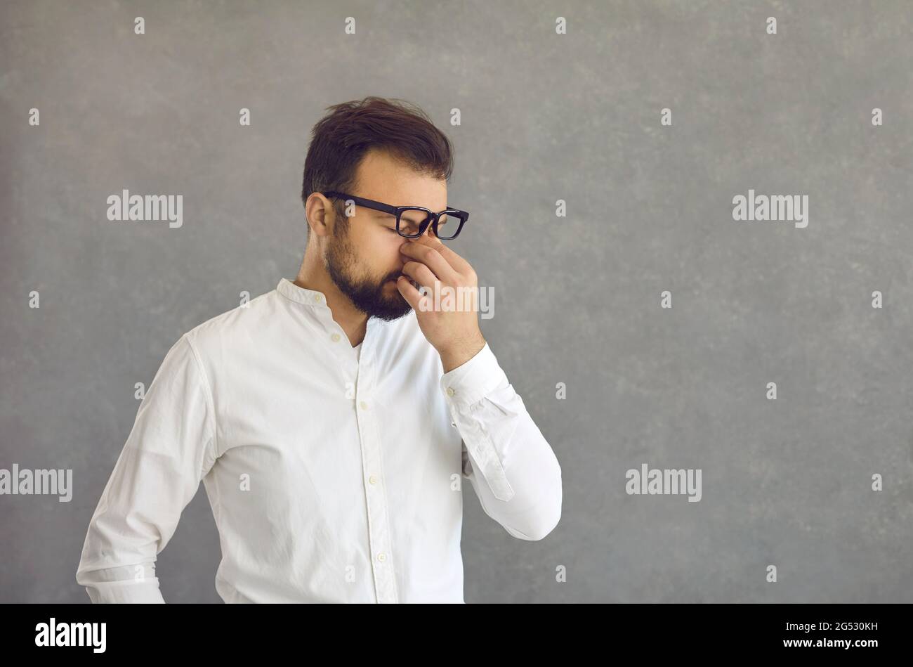 Strained And Look Tired young businessman rubbing his strained eyes after a long ...