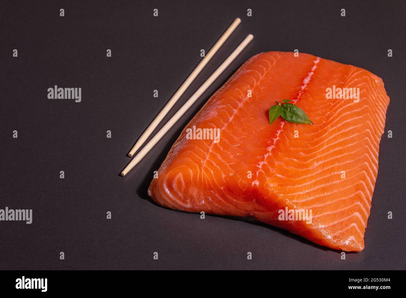 Fresh raw salmon or trout sea fish fillet on black stone background ...