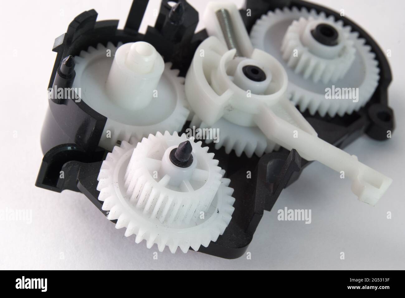 white plastic spur gears connected in complex mechanism, part of the