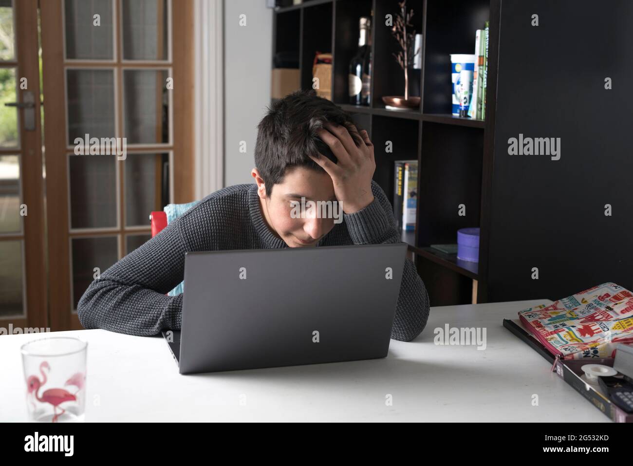 Tired  UK schoolboy, age 13-14 years, having online lessons during Covid-19 pandemic, Surrey,UK Stock Photo