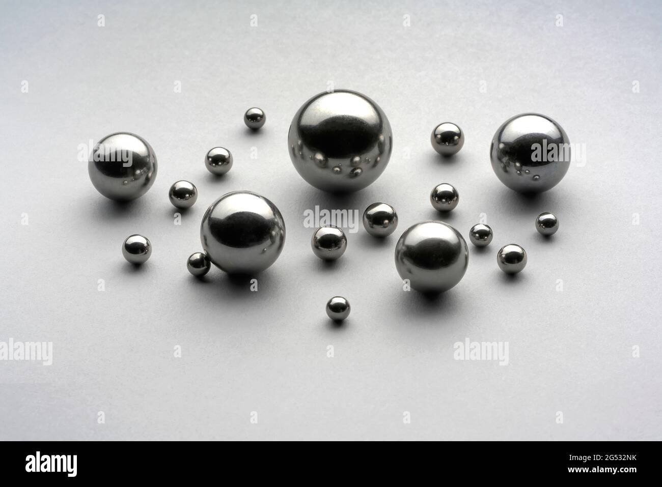 Close up top view showing group of assorted steel balls used as components  in industrial bearings displayed on grey background Stock Photo - Alamy