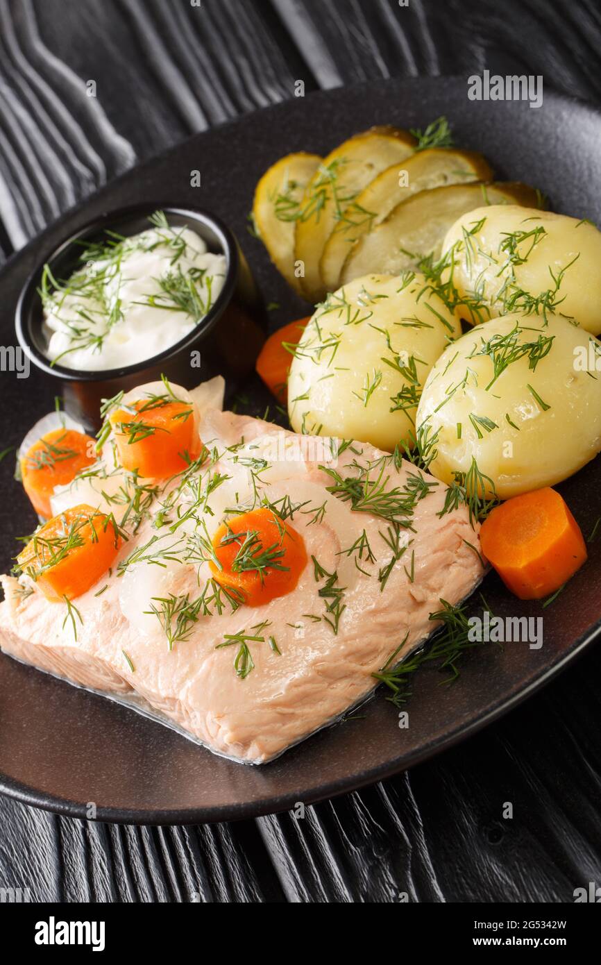 Inkokt Lax Recipe Swedish cold poached salmon with new potatoes closeup in the plate on the table. Vertical Stock Photo
