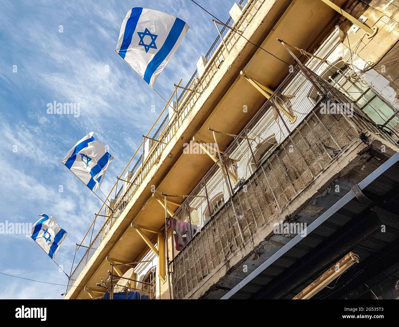 Israeli flags on the wind and the blue sky in the old Jerusalem city Stock Photo