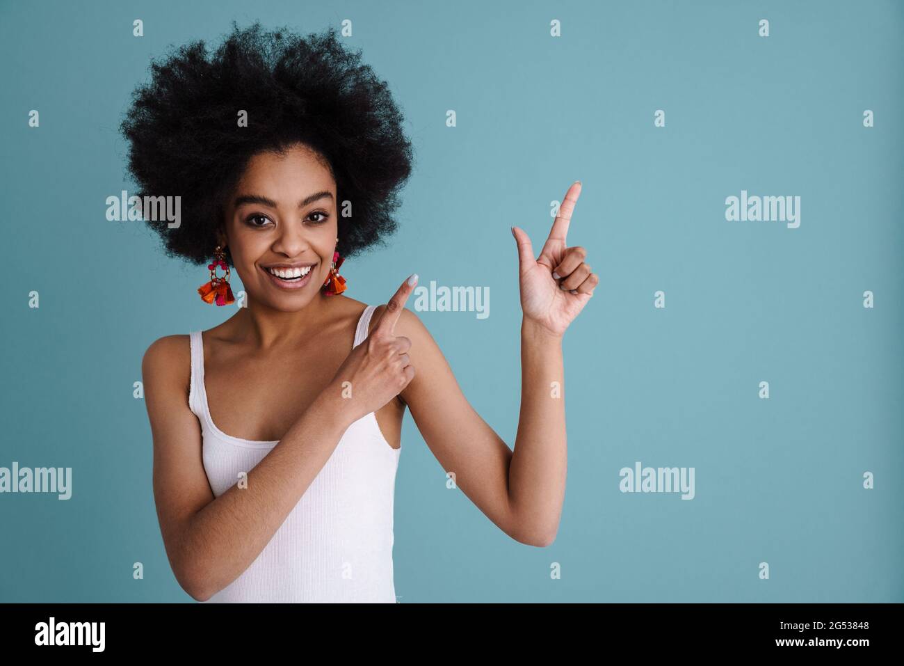 Happy african american girl smiling and pointing fingers upward ...