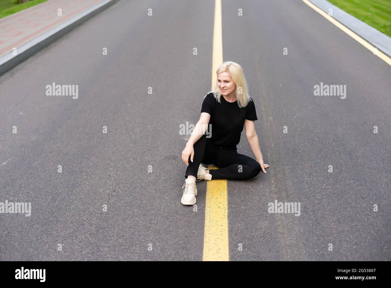 Woman walking along a country road Stock Photo - Alamy