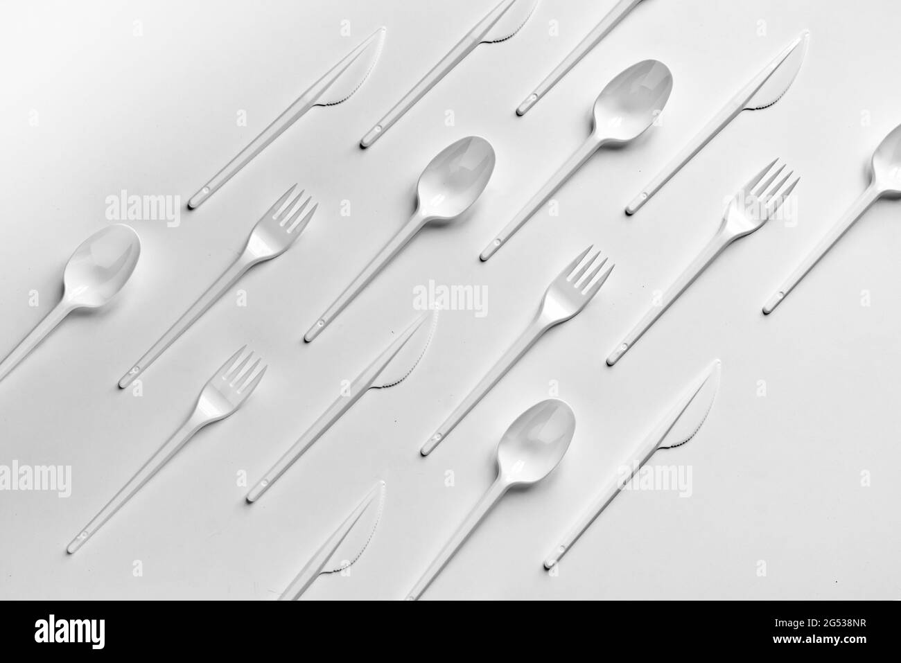 the creative flat lay of plastic forks spoons and knifes pattern Stock Photo