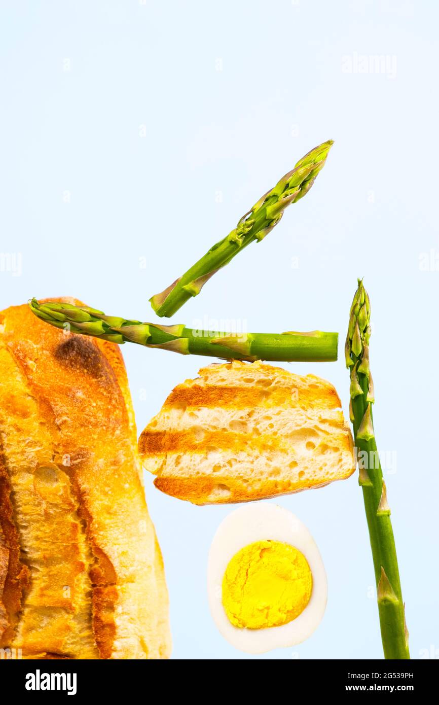 Fresh Grilled Bread, Asparagus and Egg. Ingridients for Breakfast. Equilibrium floating food. Balance levitation Food. Vertical Photo. Stock Photo
