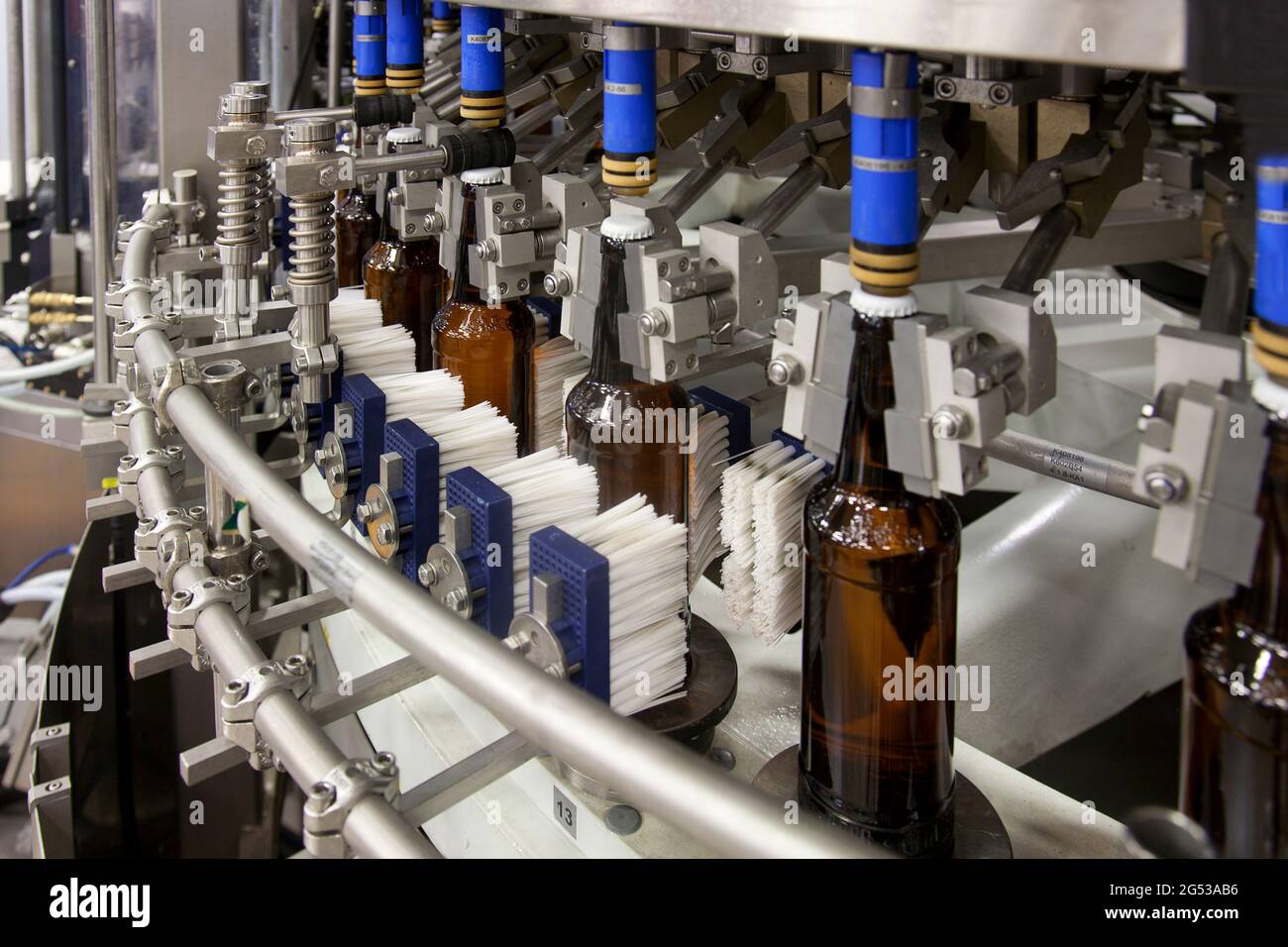 Beer bottling plant with moving belts, rows of bottles, automated