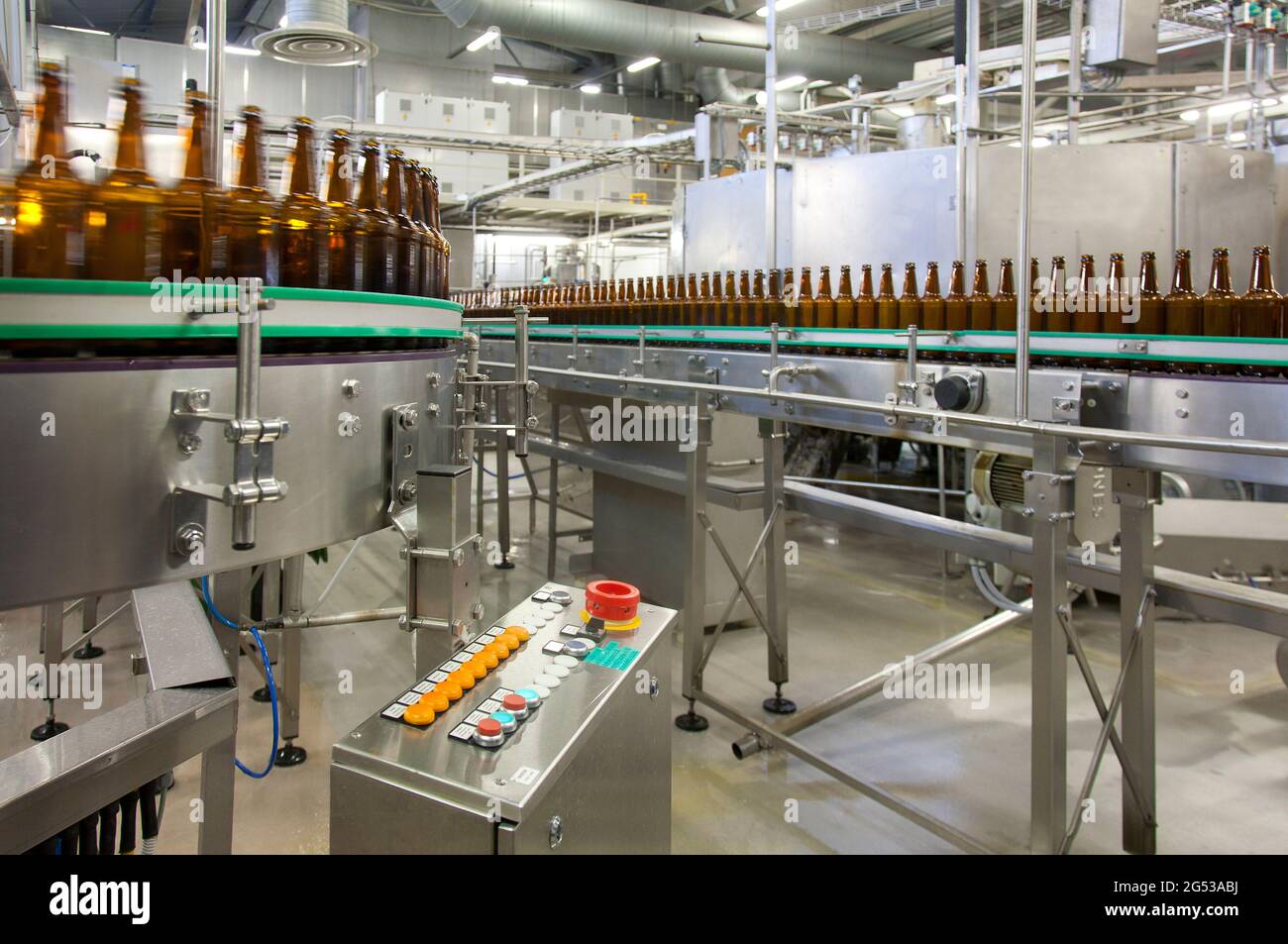 Beer bottling plant with moving belts, rows of bottles, automated