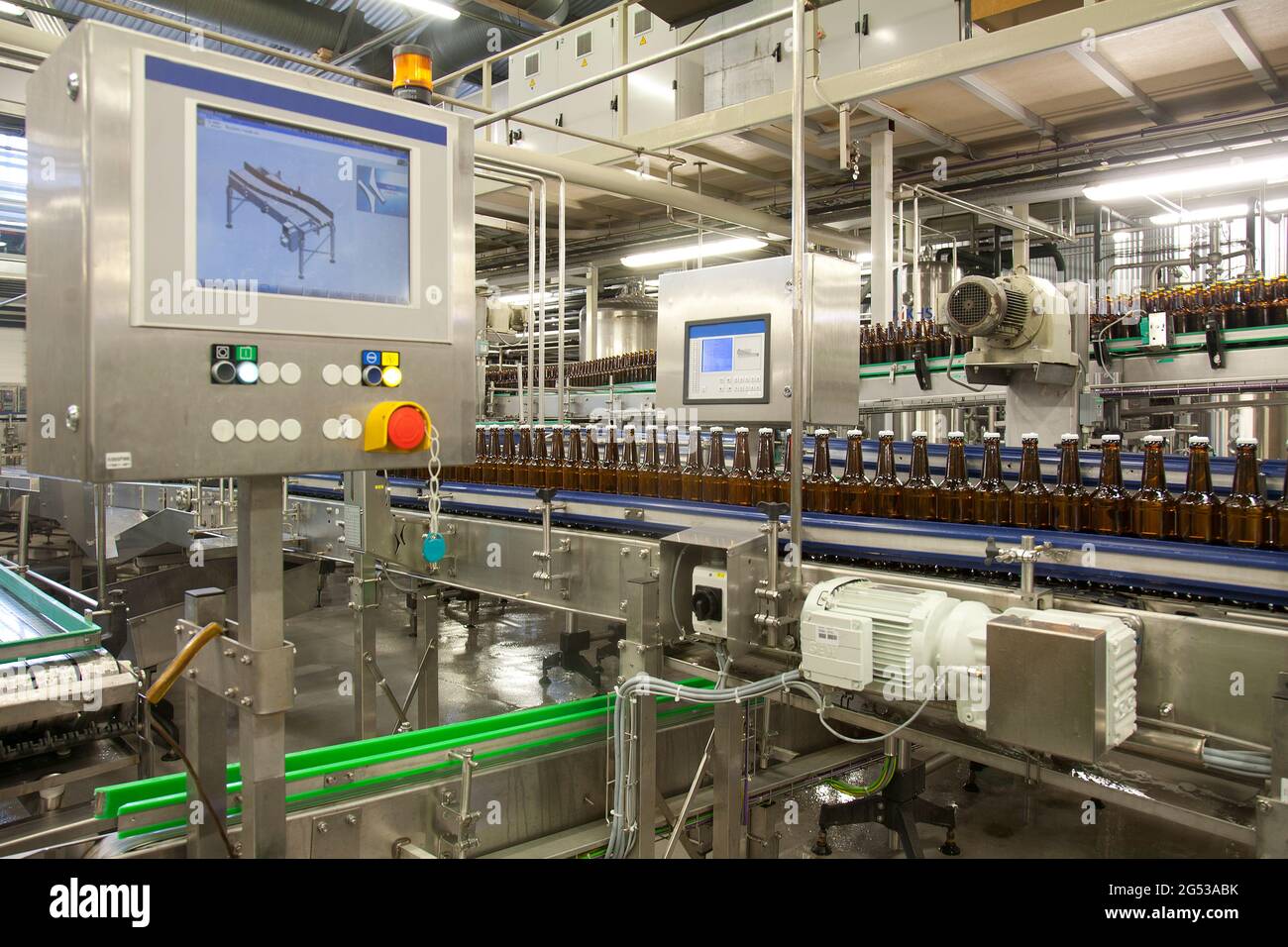 Beer bottling plant with moving belts, rows of bottles, automated process,  capping and labelling and placing in crates Stock Photo - Alamy