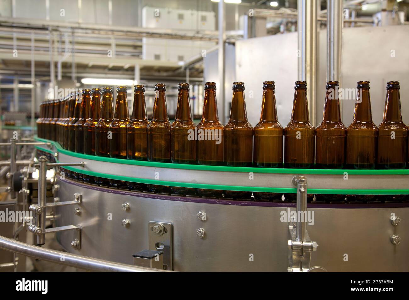 Beer bottling plant with moving belts, rows of bottles, automated