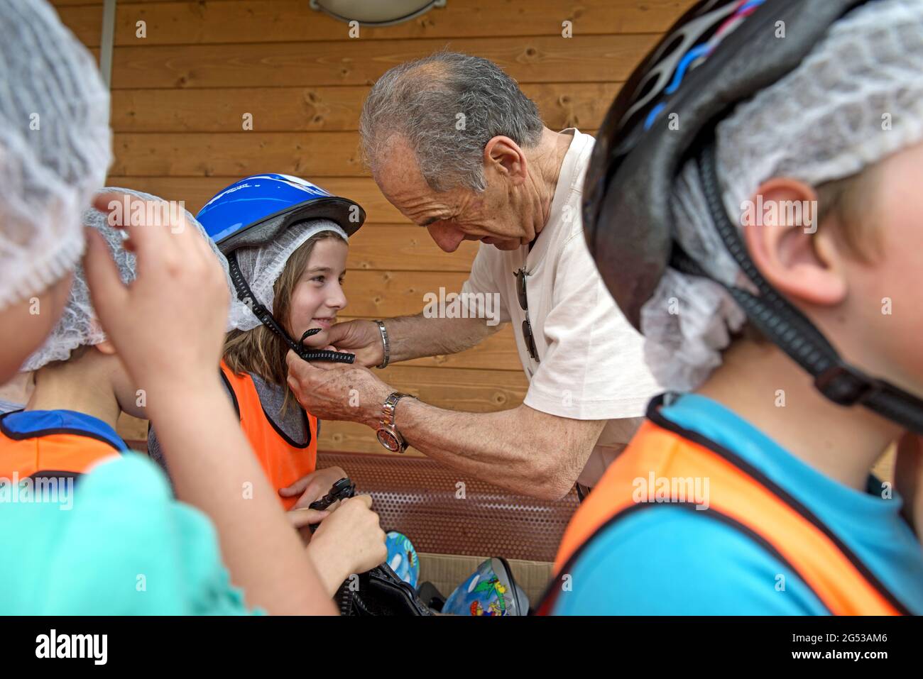 Grandfathers teaching bicycle's road rules to the children, , at Civitas Vitae, a residence for elderly, in Padua, Italy Stock Photo
