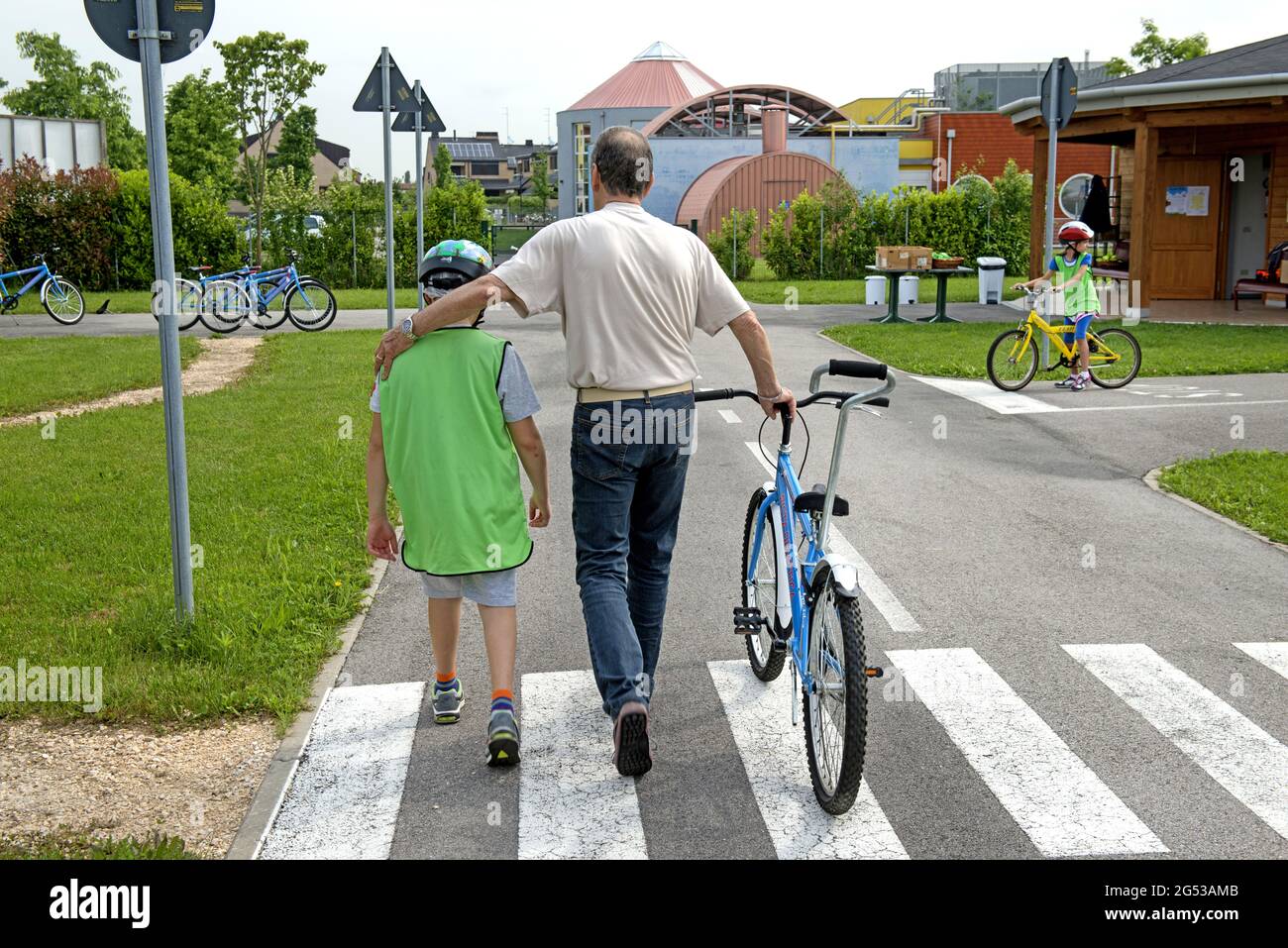 Grandfathers teaching bicycle's road rules to the children, , at Civitas Vitae, a residence for elderly, in Padua, Italy Stock Photo