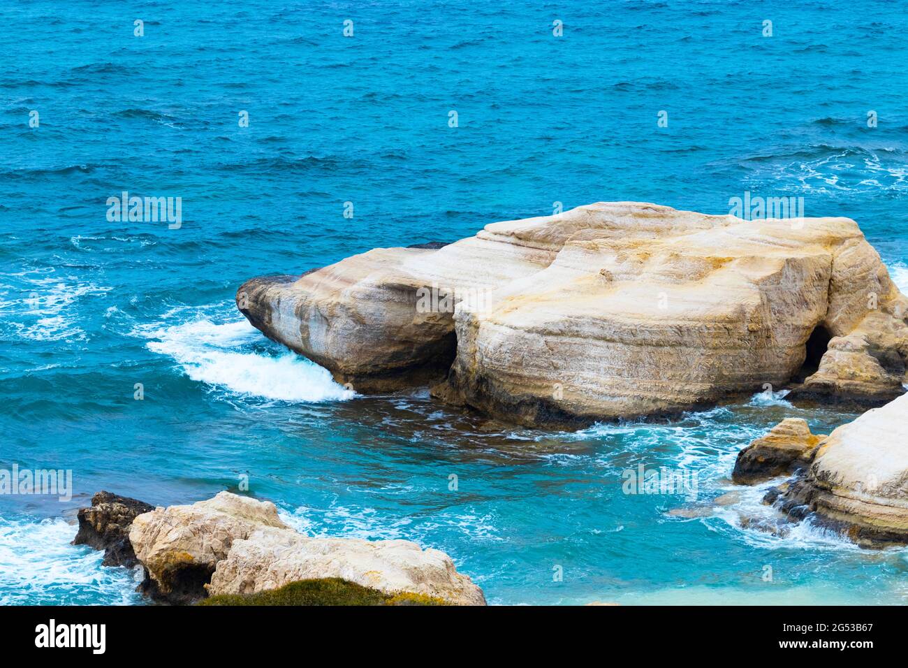 Ocean waves splash against beach with rocks background, Cliffs in the sea, Top aerial view of