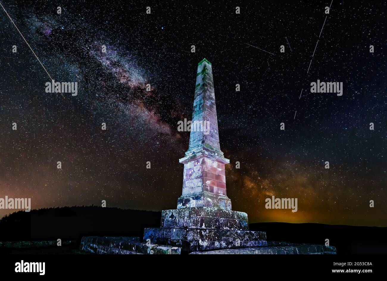 Balfour obelisk monument it up at night with Milky Way stars in the night sky and a shooting meteor, East Lothian, Scotland, UK Stock Photo