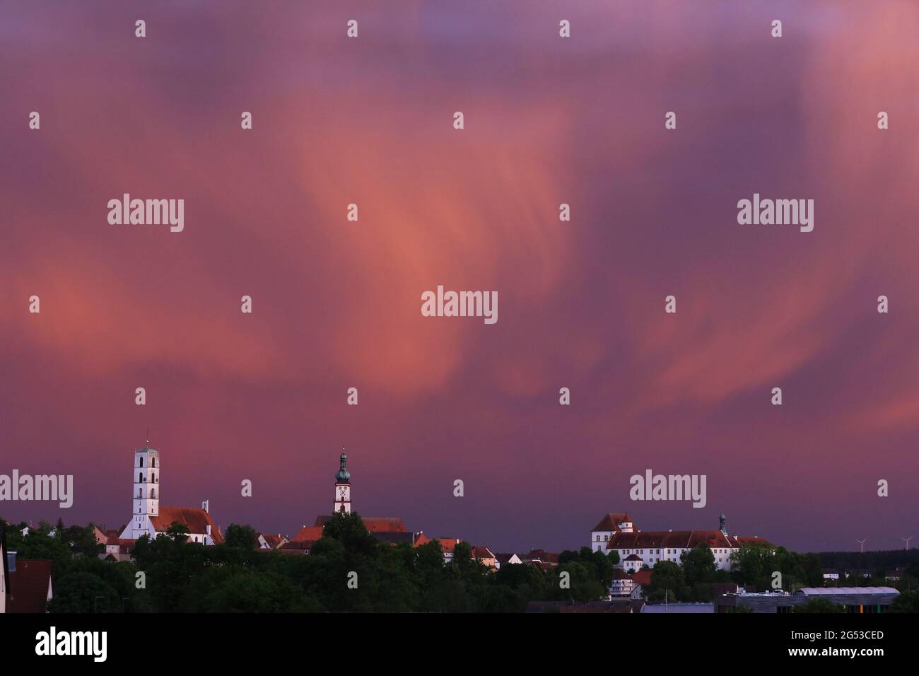 Mystische Lichtstimmung am Abendhimmel über Kirchturm und Kirche in Sulzbach-Rosenberg bei Amberg in der Oberpalz in Bayern Stock Photo