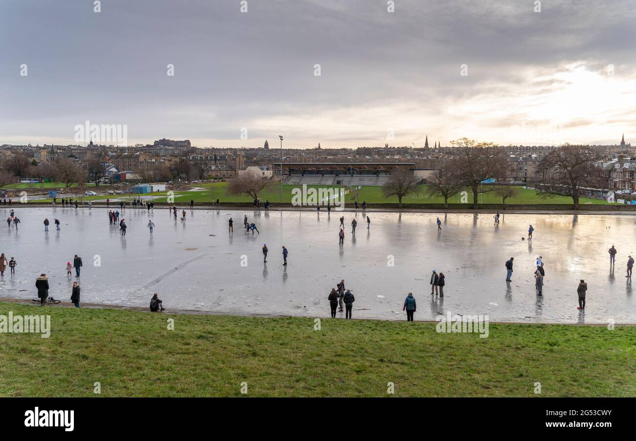 Skaters on a frozen Inverleith pond in winter  in Inverleith Park, Edinburgh, Scotland, UK Stock Photo