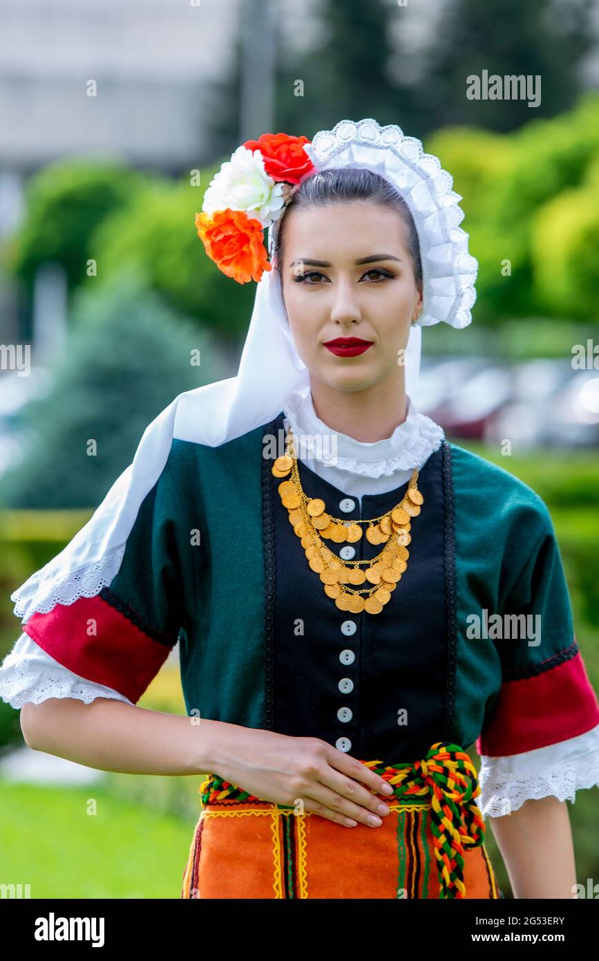 Sliven, Bulgaria - June 20th 2021: Young woman wearing traditional Bulgarian folklore dresses Stock Photo