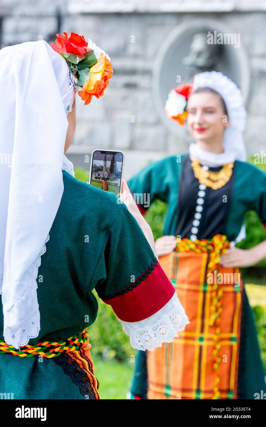 Sliven, Bulgaria - June 20th 2021: Young girls having fun wearing traditional Bulgarian folklore dresses Stock Photo