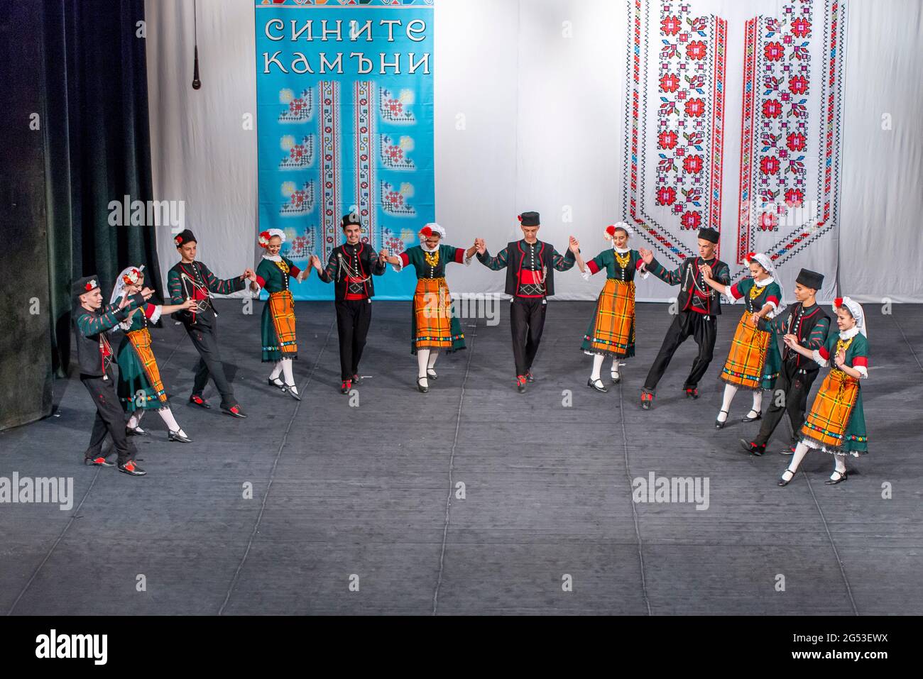 Sliven, Bulgaria - June 20th 2021: Young Bulgarian men and women performing folk dances in traditional dress Stock Photo