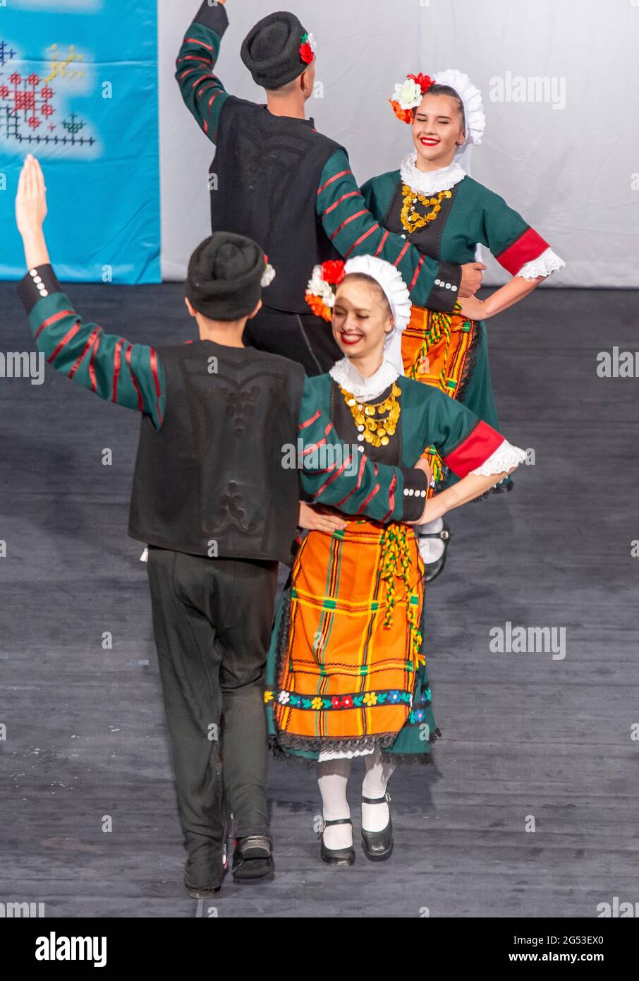 Sliven, Bulgaria - June 20th 2021: Young Bulgarian men and women performing folk dances in traditional dress Stock Photo
