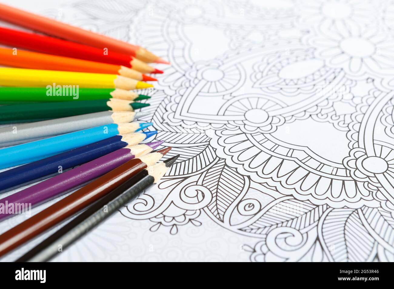 Adult coloring book and crayons on the table Stock Photo Alamy