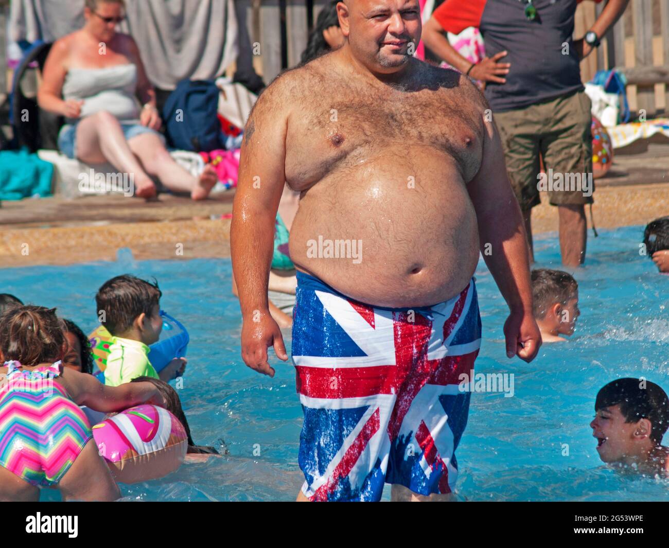 A large man in a Brighton paddling pool Stock Photo Alamy