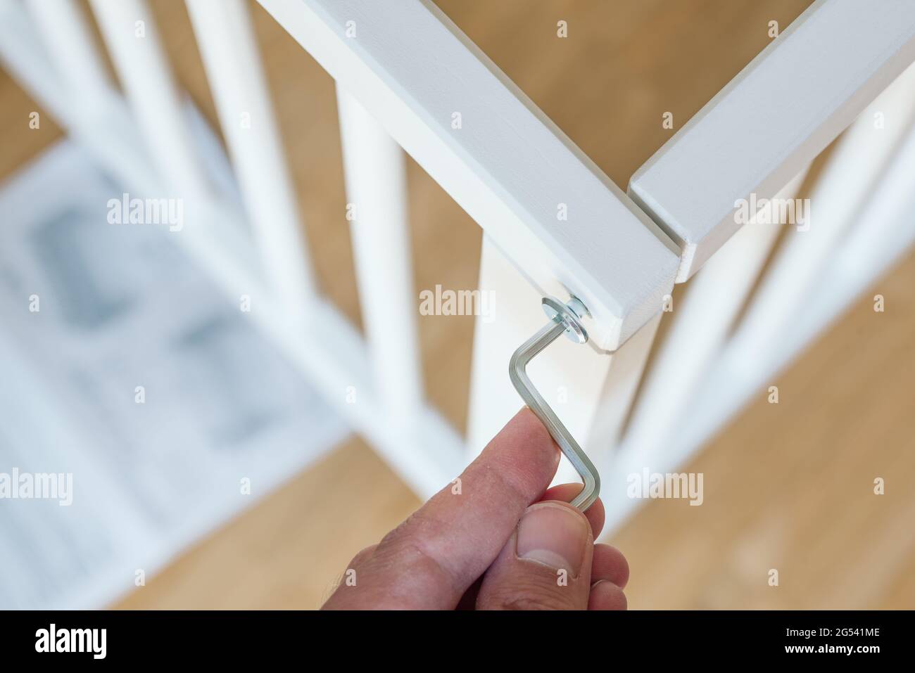 close-up of person assembling furniture using a hex wrench Stock Photo