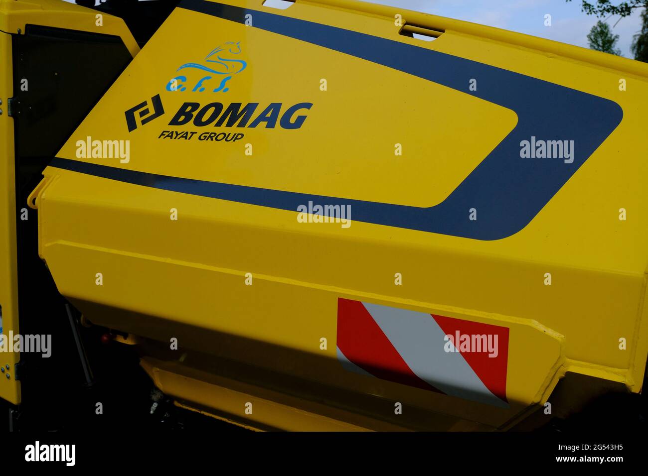 June 2021 Parma, Italy: Huge yellow Bomag heavy road machine close-up parked and ready for road construction and tarmacking. Asphalt paver machine Stock Photo
