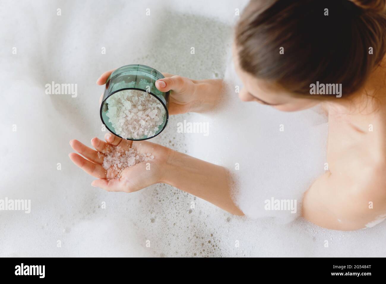 Top view of woman sitting in foam bath with sea bath salt in hands Stock Photo Alamy