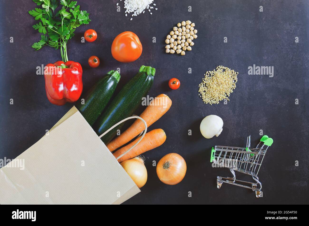 Shopping or delivery healthy food concept. Food supermarket and clean vegan eating concept. Fresh vegetables, fruit: in paper bag on black background Stock Photo