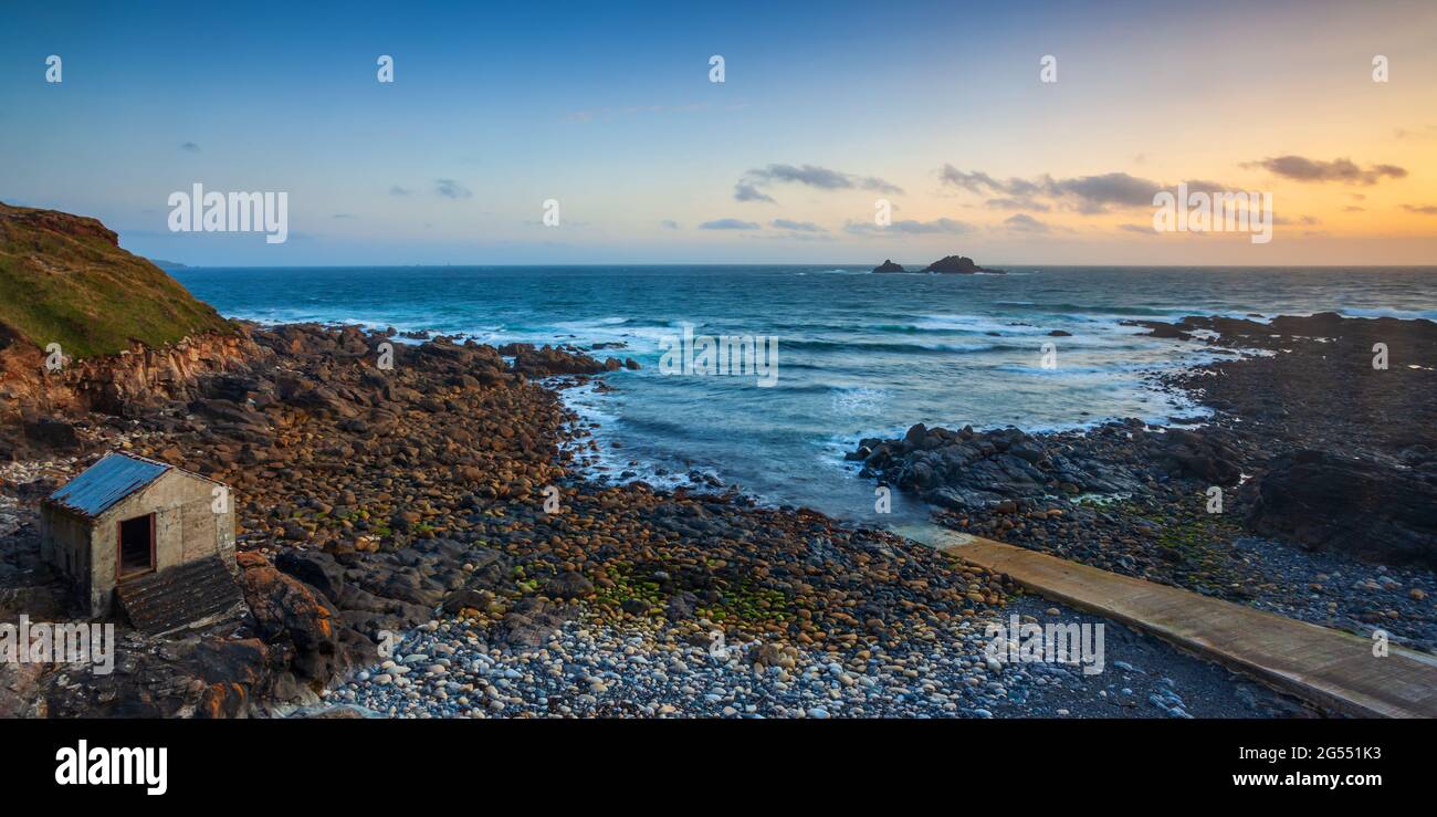 Sunset at Priest Cove near St Just in Cornwall, with the Brisons Rocks in the distance. Stock Photo