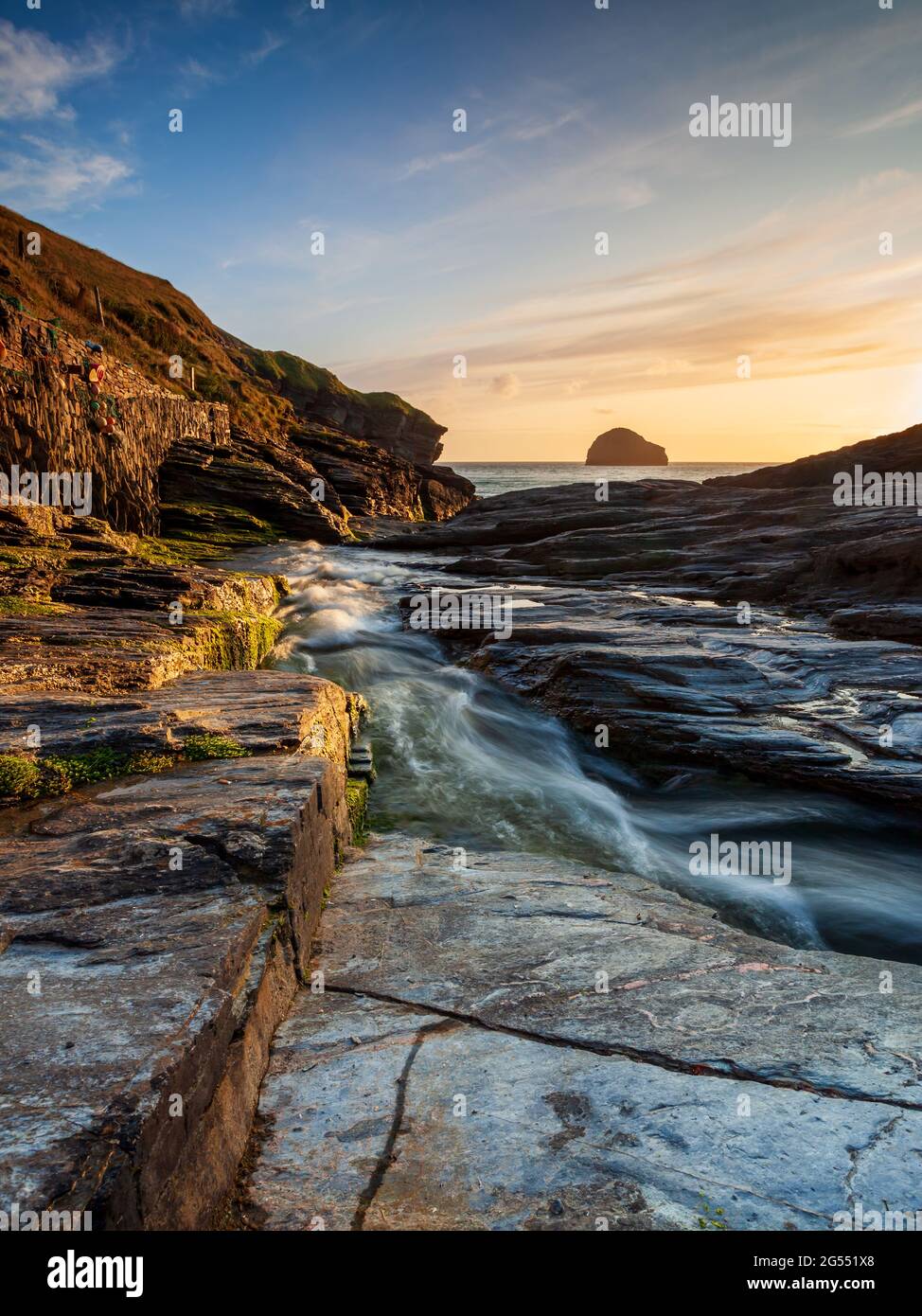 Sunset at Trebarwith Strand on the North Cornwall coast, with Gull Rock on the horizon. Stock Photo