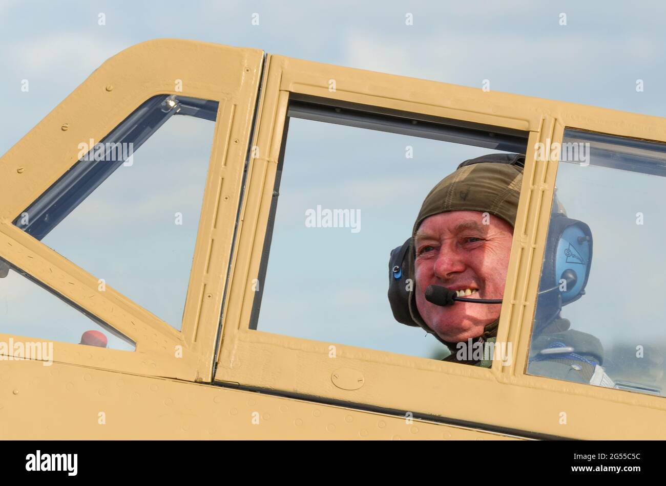 Pilot Air Marshal Cliff Spink (RAF) inside the cramped cockpit canopy of a Hispano Buchon (Messerschmitt Me109) WWII fighter plane. Framed canopy Stock Photo