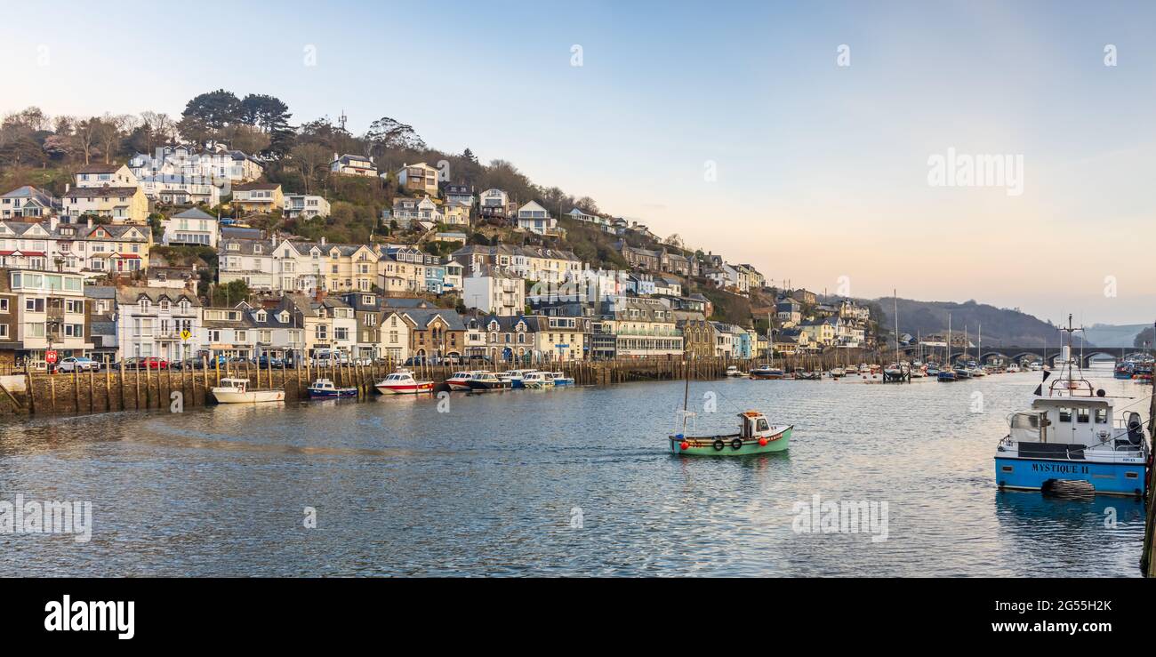 A small fishing boat crossing the Looe River in the early morning at Looe harbour in Cornwall. Stock Photo