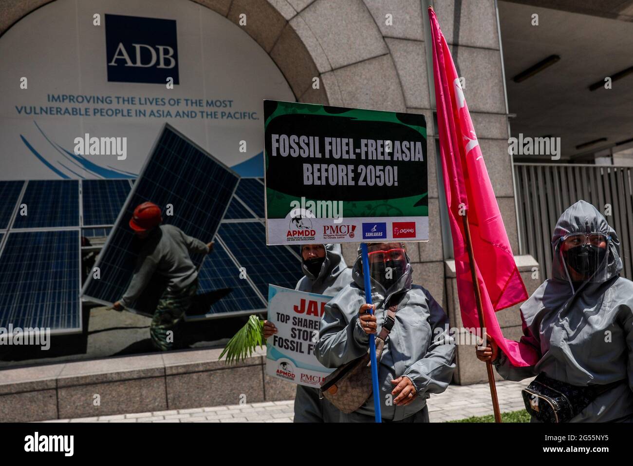 Climate activists dressed in PPE suits protest outside the Asian Development Bank (ADB) headquarters in Mandaluyong City. The group called on ADB—currently hosting the Asia Clean Energy Forum—and participating financial institutions to stop funding fossil fuel projects and make the shift to renewable energy. Metro Manila, Philippines. Stock Photo