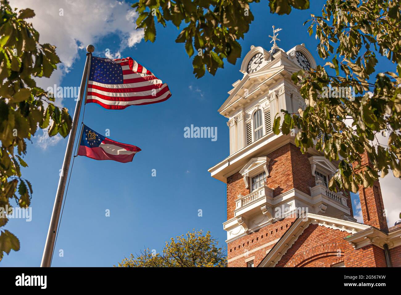 American flag and Georgia state flag waving in front of the Gwinnett Historic Courthouse on the town square in Lawrenceville, Georgia. (USA) Stock Photo