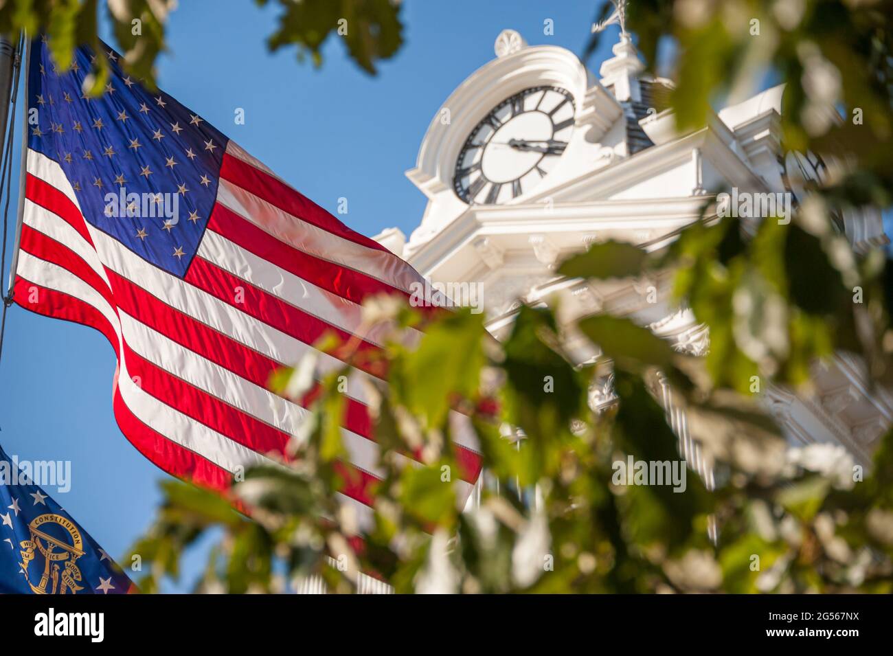 American flag and Georgia state flag at the Gwinnett Historic Courthouse on the town square in Lawrenceville, Georgia. (USA) Stock Photo