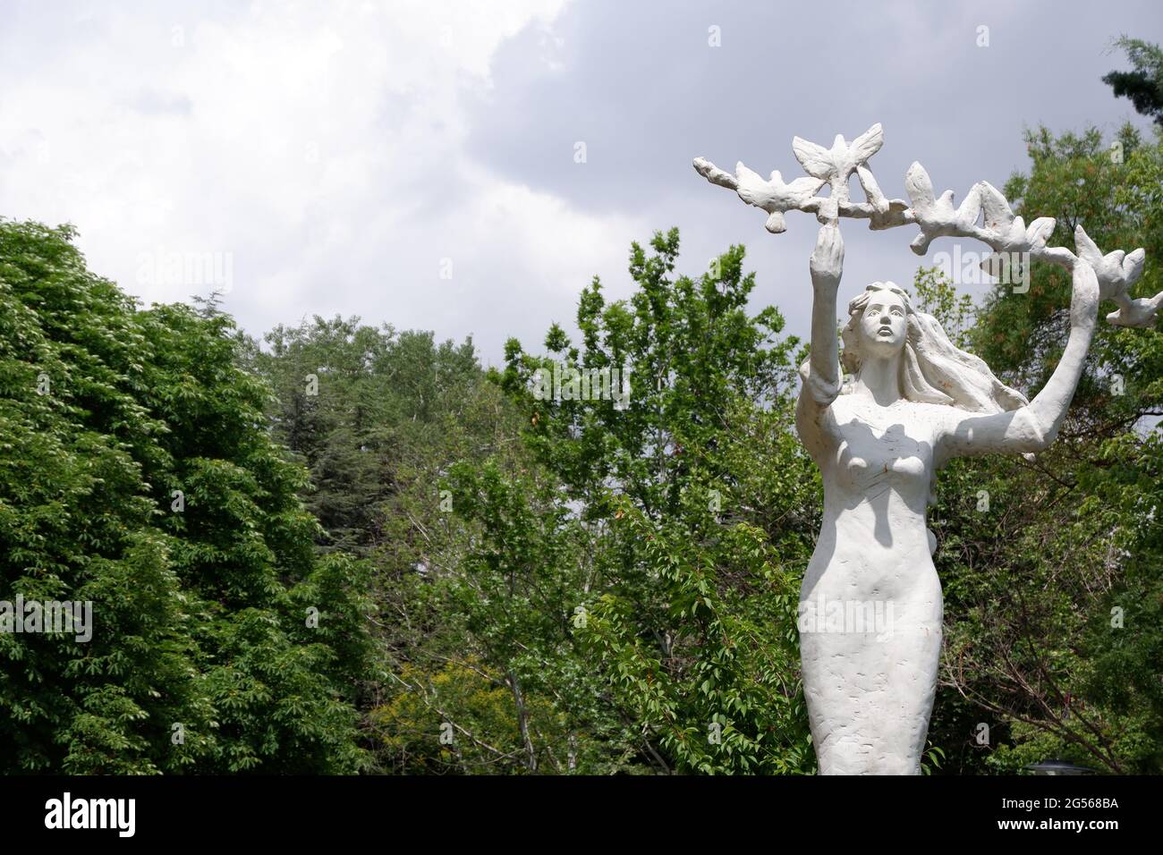 Statue of a young woman holding a branch with doves Stock Photo