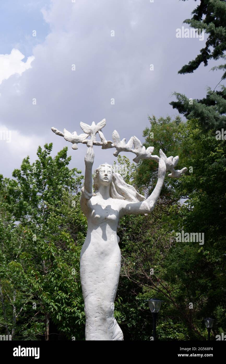 Statue of a young woman holding a branch with doves Stock Photo