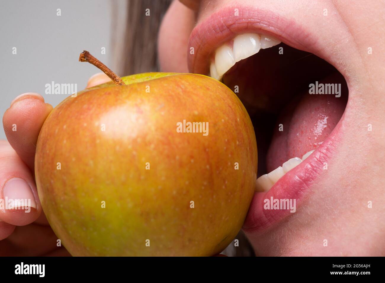 Woman eating apple healthy diet and healhy teeth. Biting an apple
