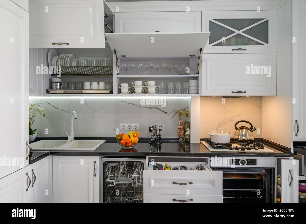 Luxurious white modern kitchen interior, drawers pulled out, dishwasher
