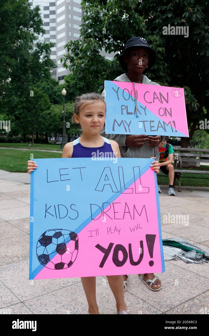 Ohio, USA. 25th June, 2021. Children holding placards supporting trans children, during the demonstration.Transgender rights advocates stood outside of the Ohio Statehouse at noon to oppose and bring attention to an amendment to a bill that would ban transgender women from participating in high school and college women sports. The original bill that this transgender ban was added to dealt with compensation for college students to profit off of their name, image and likeness. The addition of transgender ban to this bill was a surprise, because a transgender ban bill already is in existence. Cre Stock Photo
