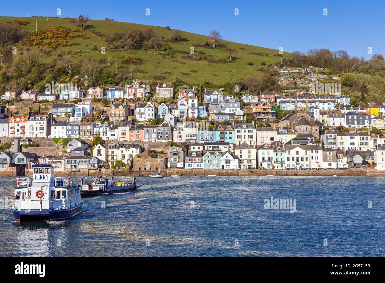 The lower Dart passenger and car ferries crossing the river Dart with the colourful buildings of Dartmouth in the background. Stock Photo