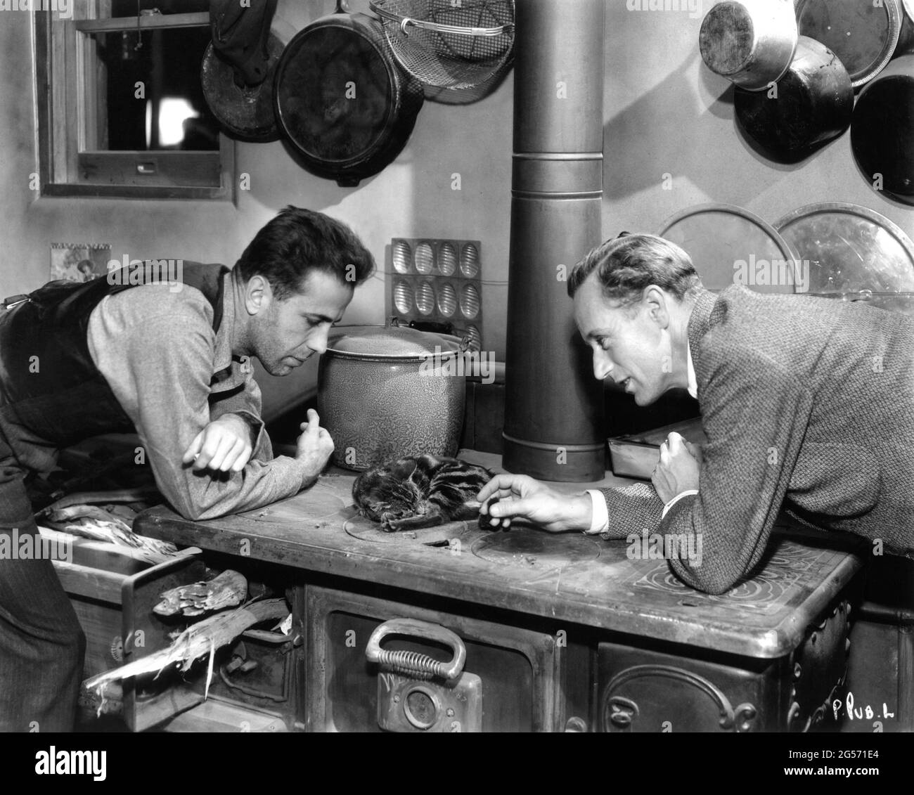 HUMPHREY BOGART and LESLIE HOWARD on set candid with a Cat during a break in filming of THE PETRIFIED FOREST 1936 director ARCHIE MAYO play Robert E. Sherwood screenplay Charles Kenyon and Delmer Daves Warner Bros. Stock Photo