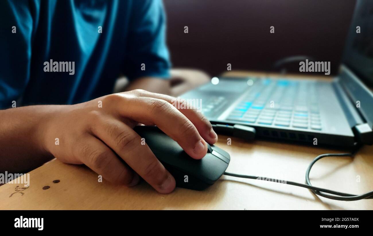 Guy gaming on his sleek laptop in his home Stock Photo - Alamy