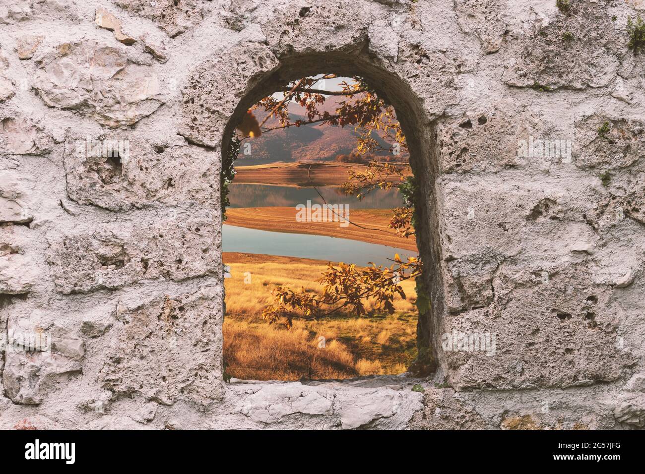Scenic view of a tranquil lake seen through a stone arch window Stock ...