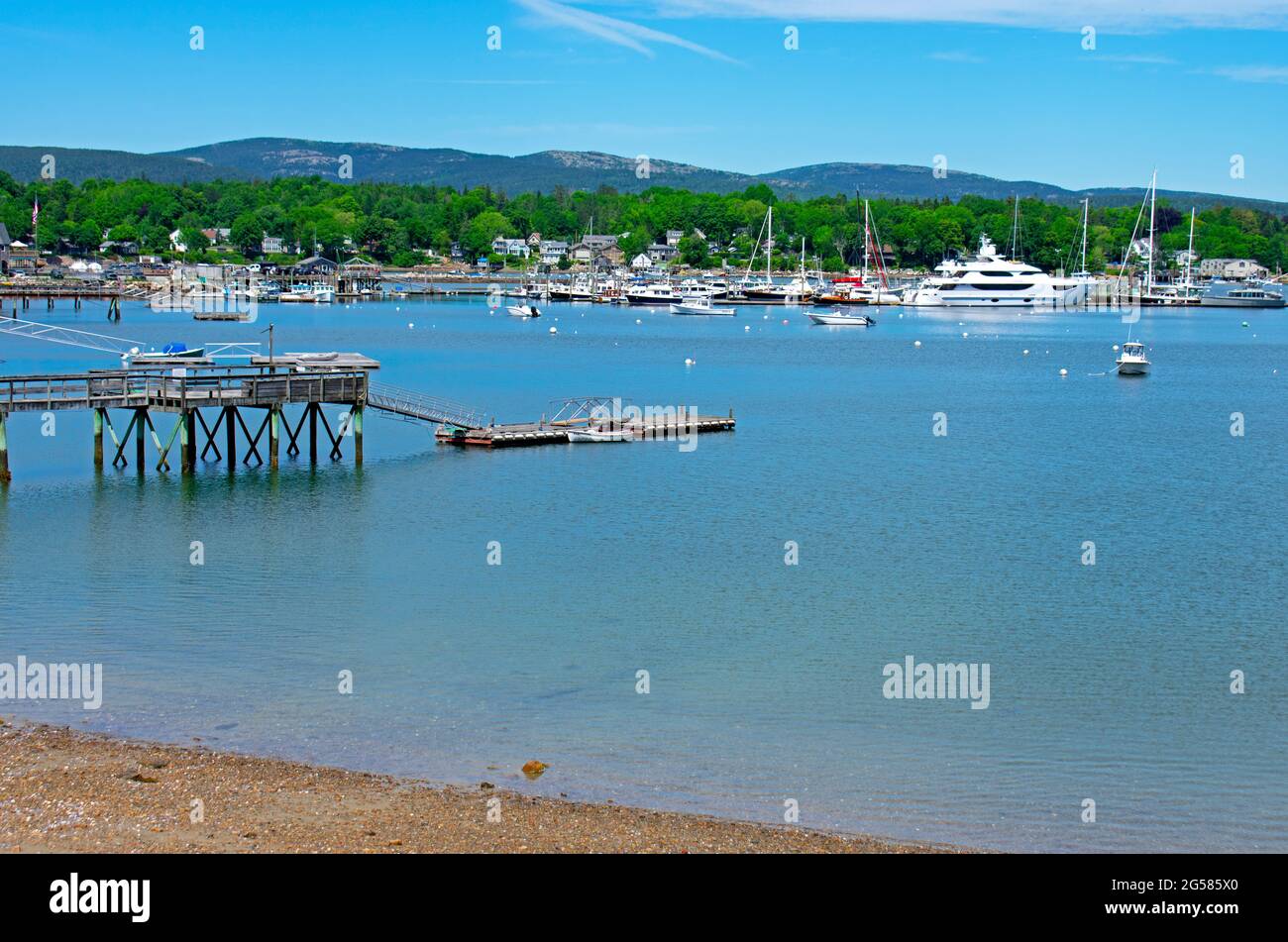 Variety of nautical vessels moored on calm blue waters of a Maine harbor under a blue sky with some cirrus clouds -05 Stock Photo
