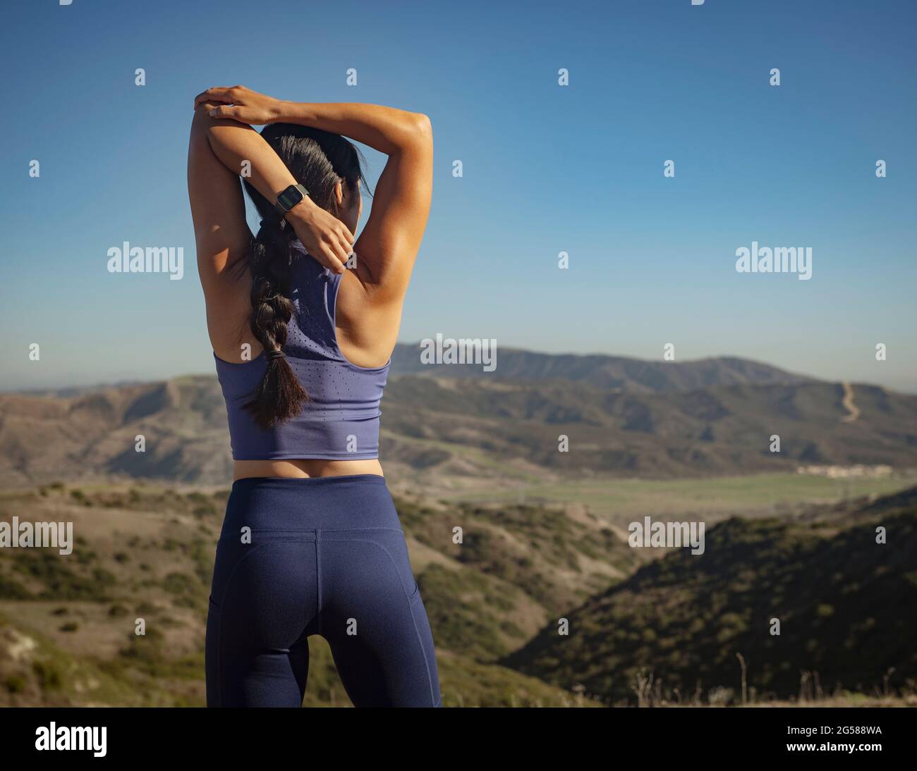 Rear view of woman stretching in landscape Stock Photo